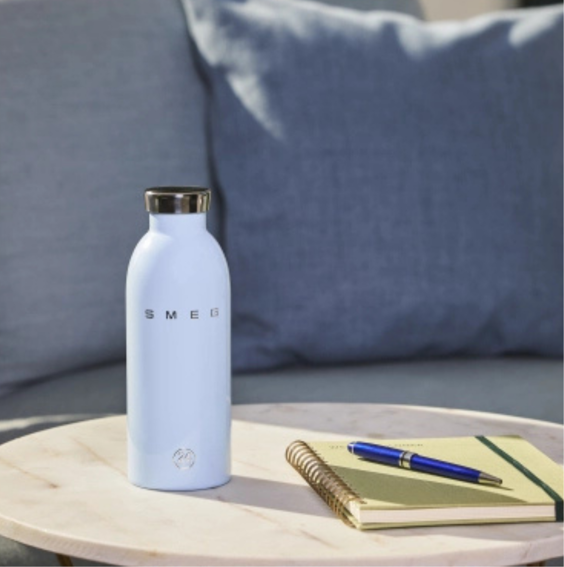SMEG Clima Bottle Pastel Blue 500 ml lifestyle image with coffee and desk setup